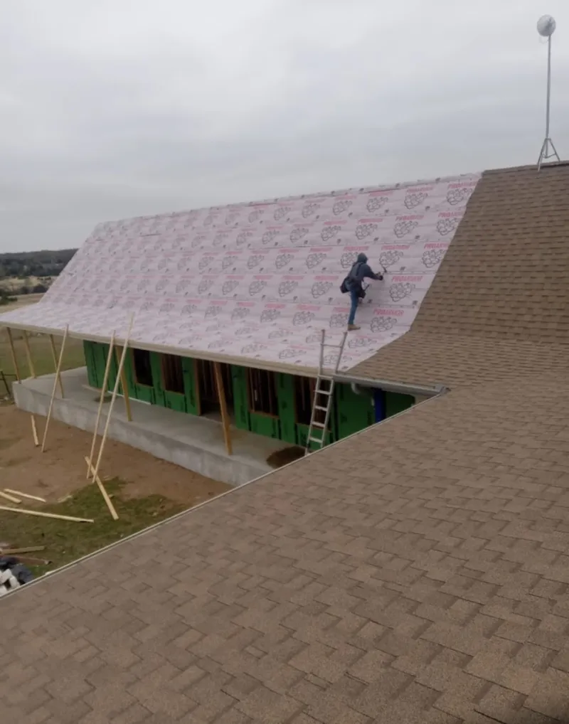 Worker preparing underlayment for a metal roof installation in Helena Valley Northwest